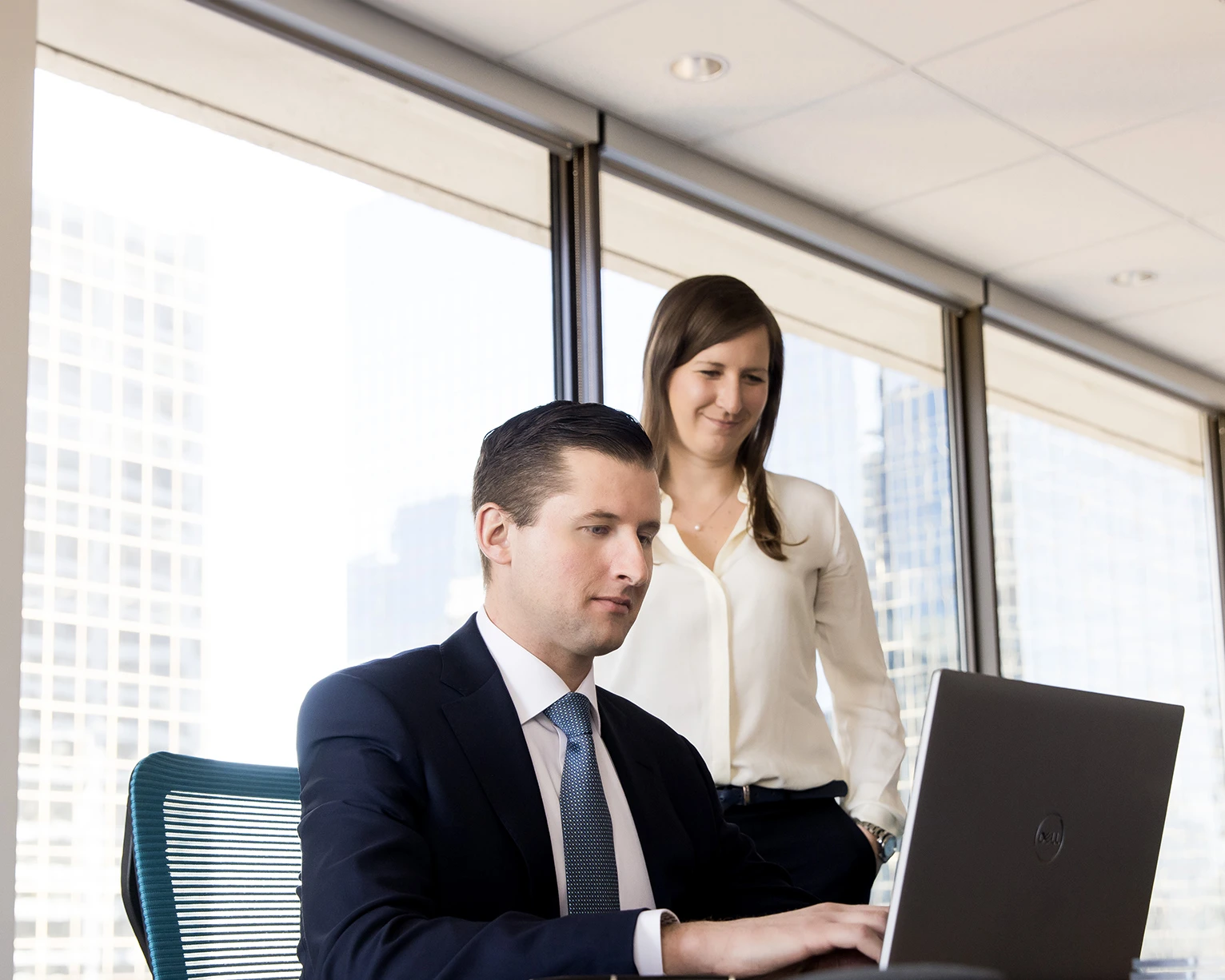 Two due diligence professionals looking at a laptop